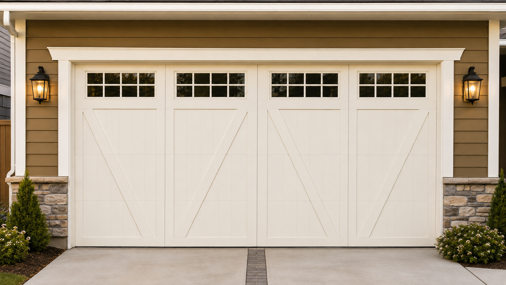 White double garage door on a beige house with stone accents and wall lanterns