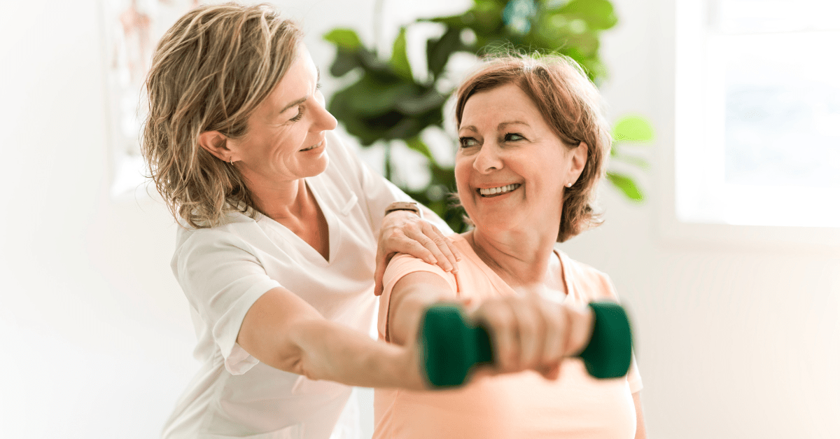 A nurse is helping an older woman lift a dumbbell.