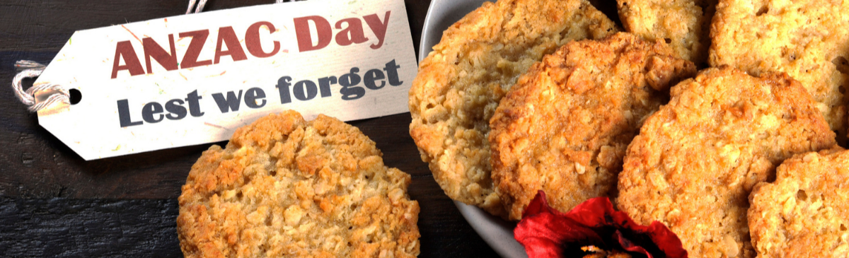 A plate of cookies next to a sign that says `` anzac day lest we forget ''.
