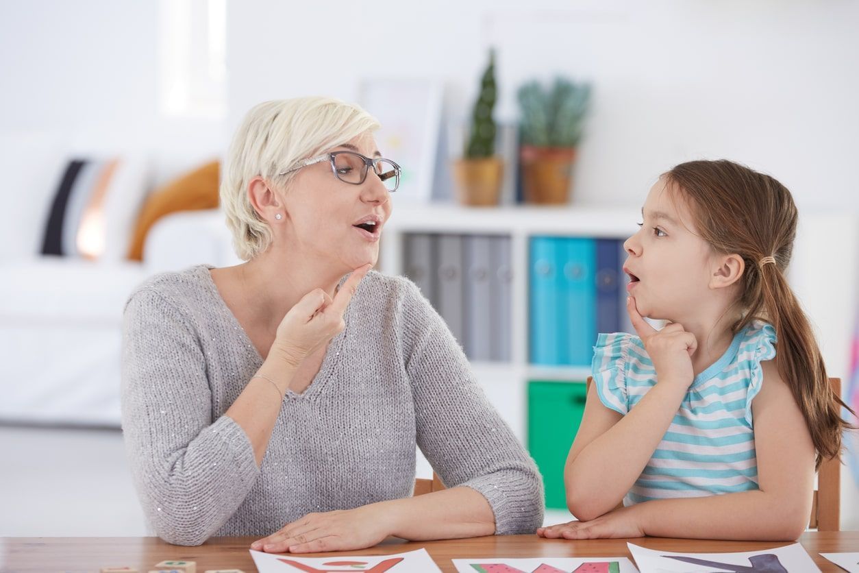 speech pathologist in Australia doing communication exercises with young client 