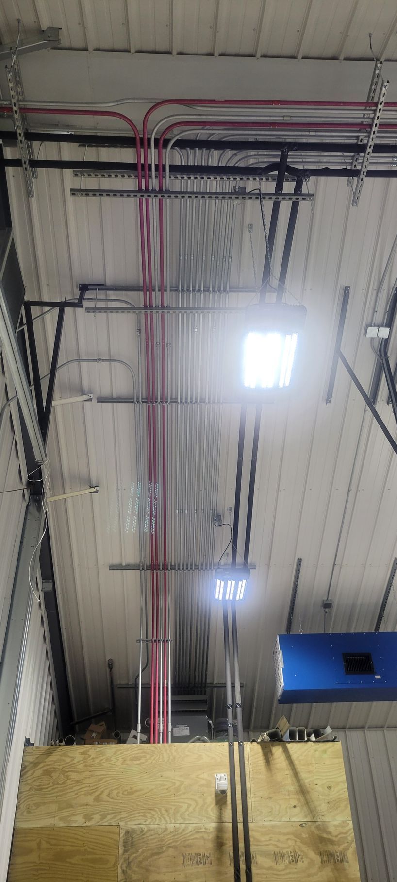 There are a lot of wires hanging from the ceiling of a building.