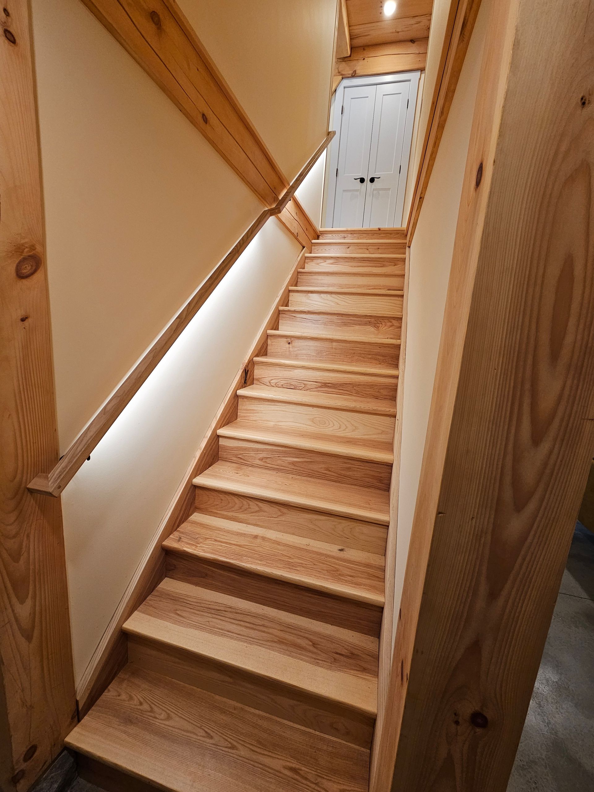 A wooden staircase leading up to a white door