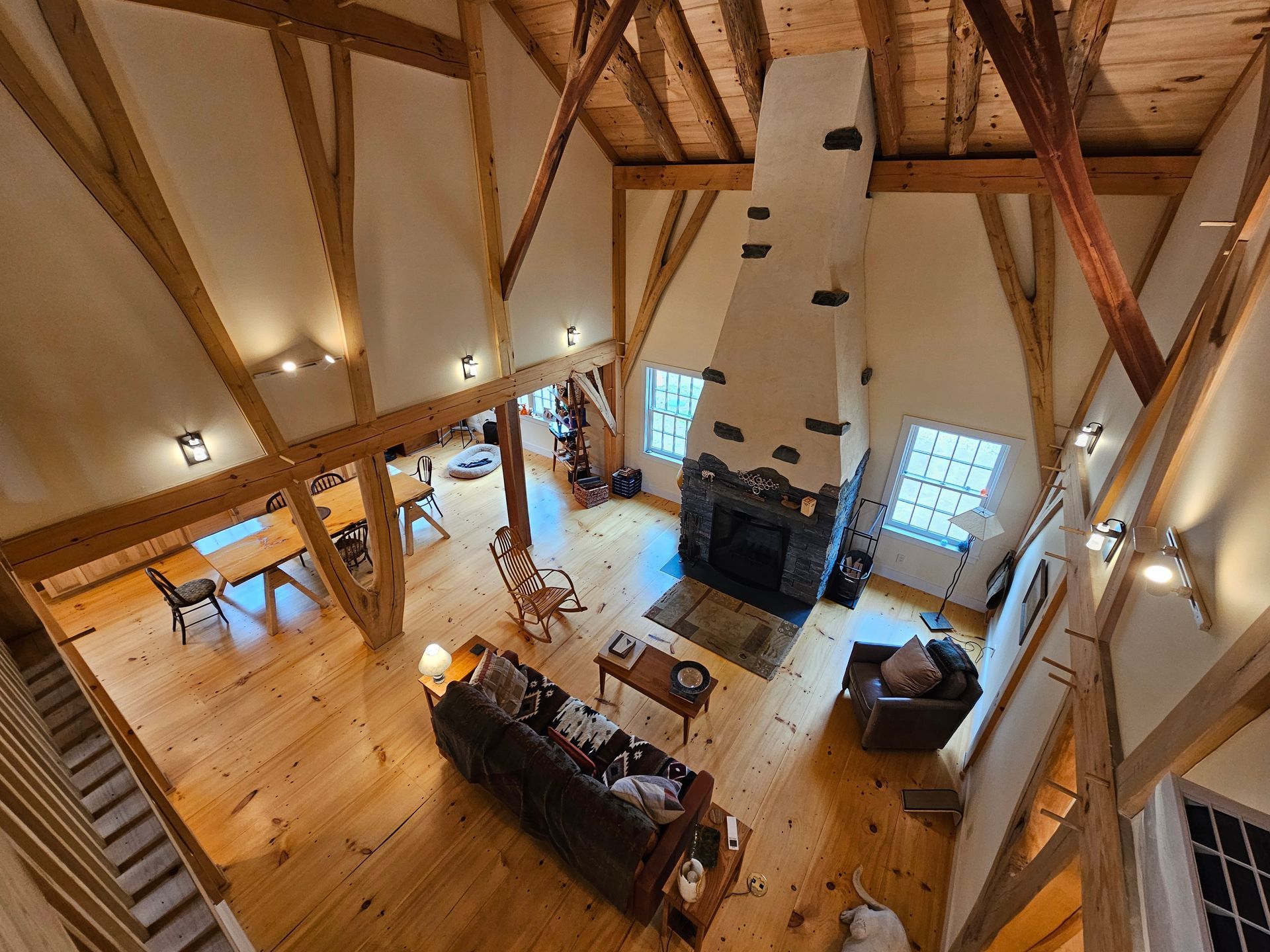 An aerial view of a living room with a fireplace and wooden beams.