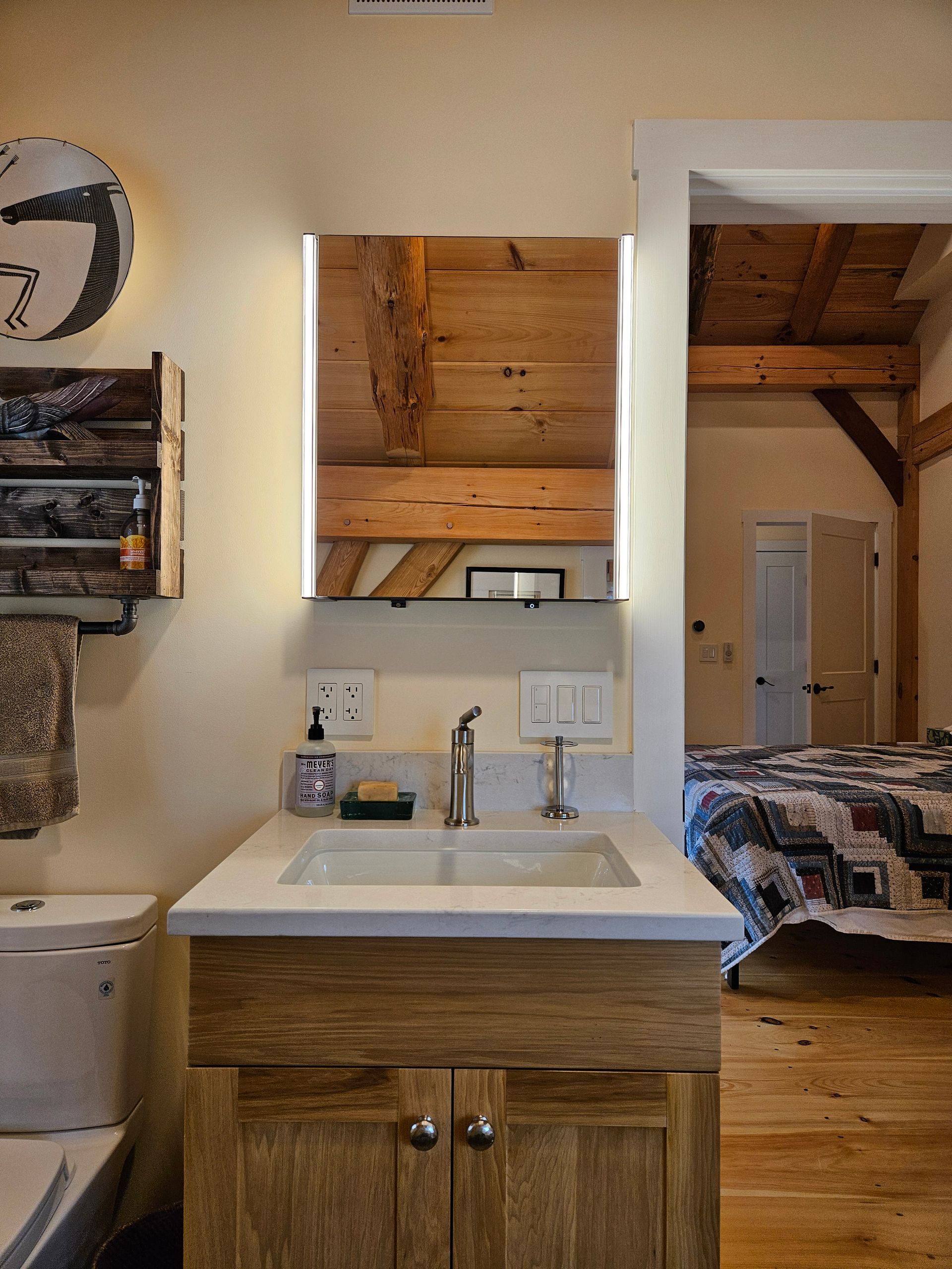 A bathroom with a sink , mirror and toilet.