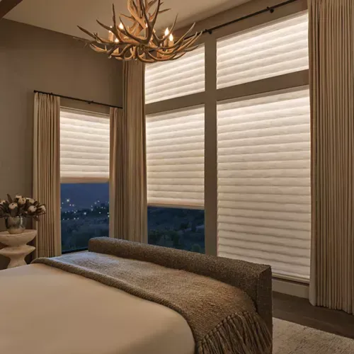 A bedroom with a bed and a chandelier hanging from the ceiling.