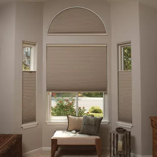 A living room with a chair and a window with blinds.