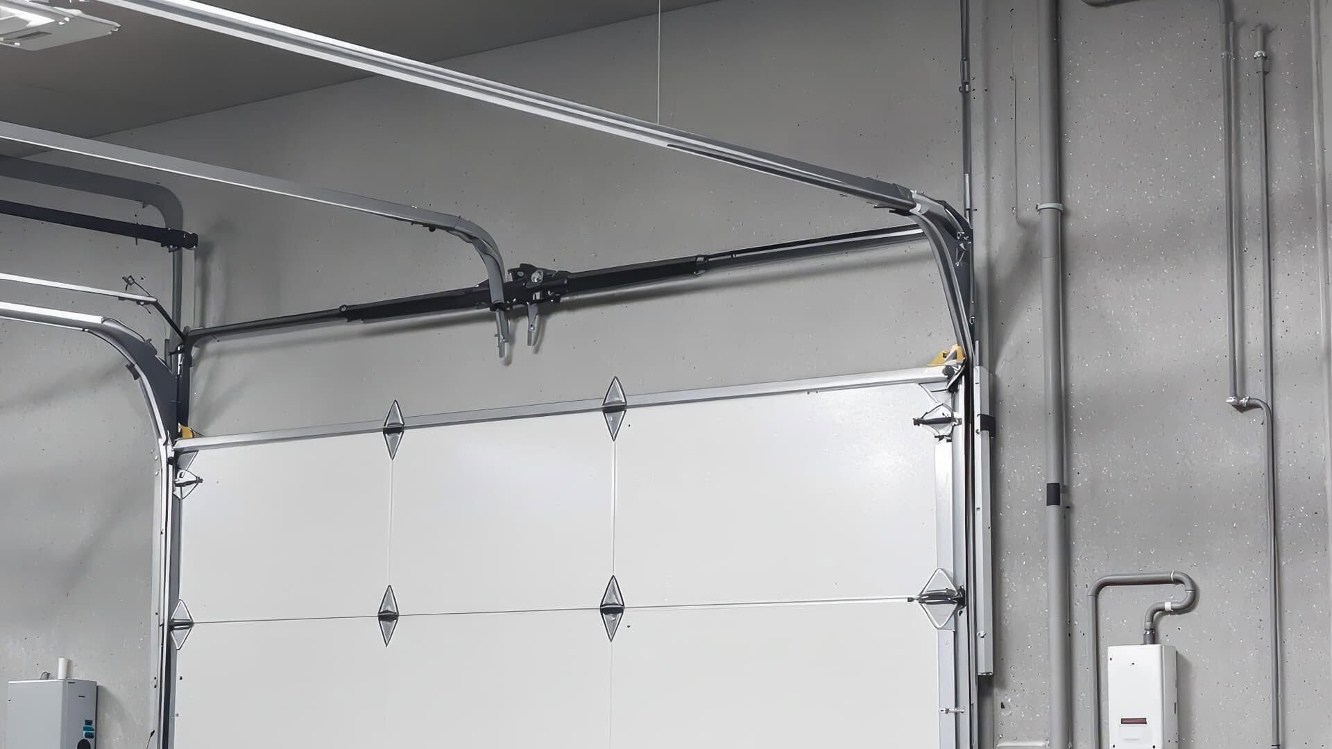 Garage door with white panels and metal track hardware on a gray wall