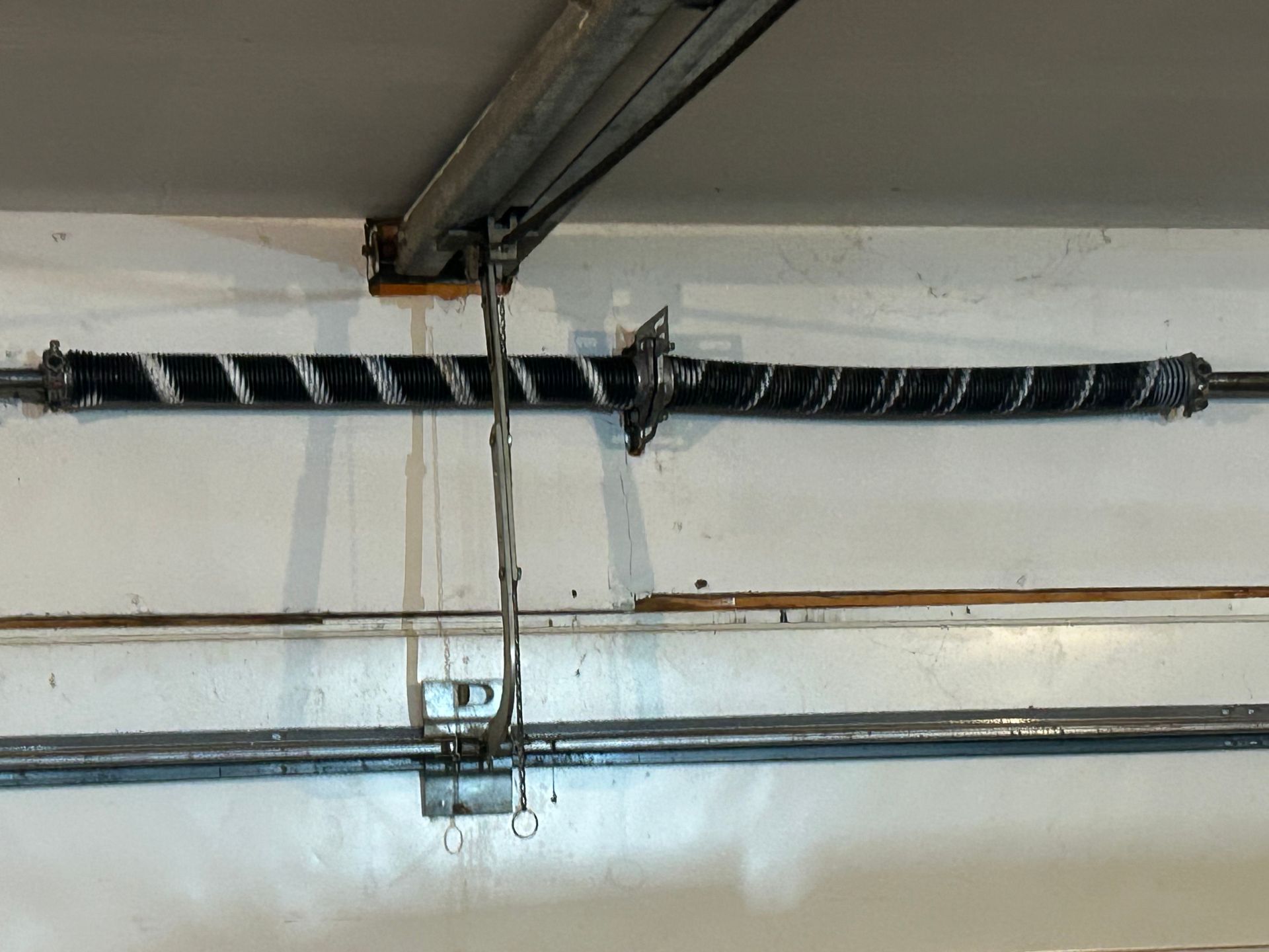 Ceiling-mounted garage door opener rail with cables and a central motor bracket
