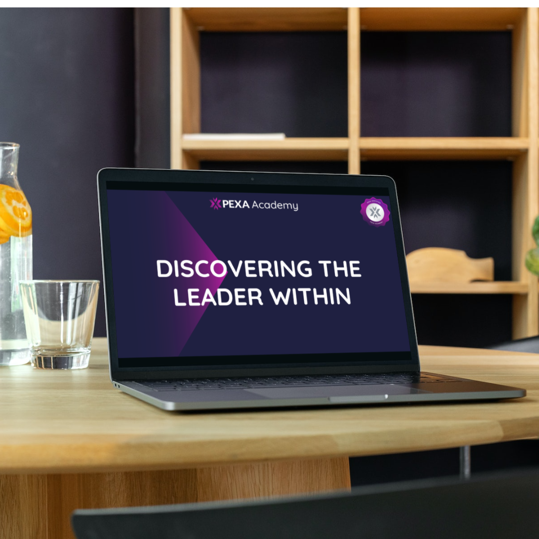 A laptop on a desk that says discovering the leader within