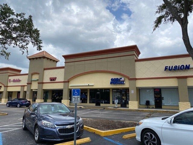 A row of cars are parked in front of a building.