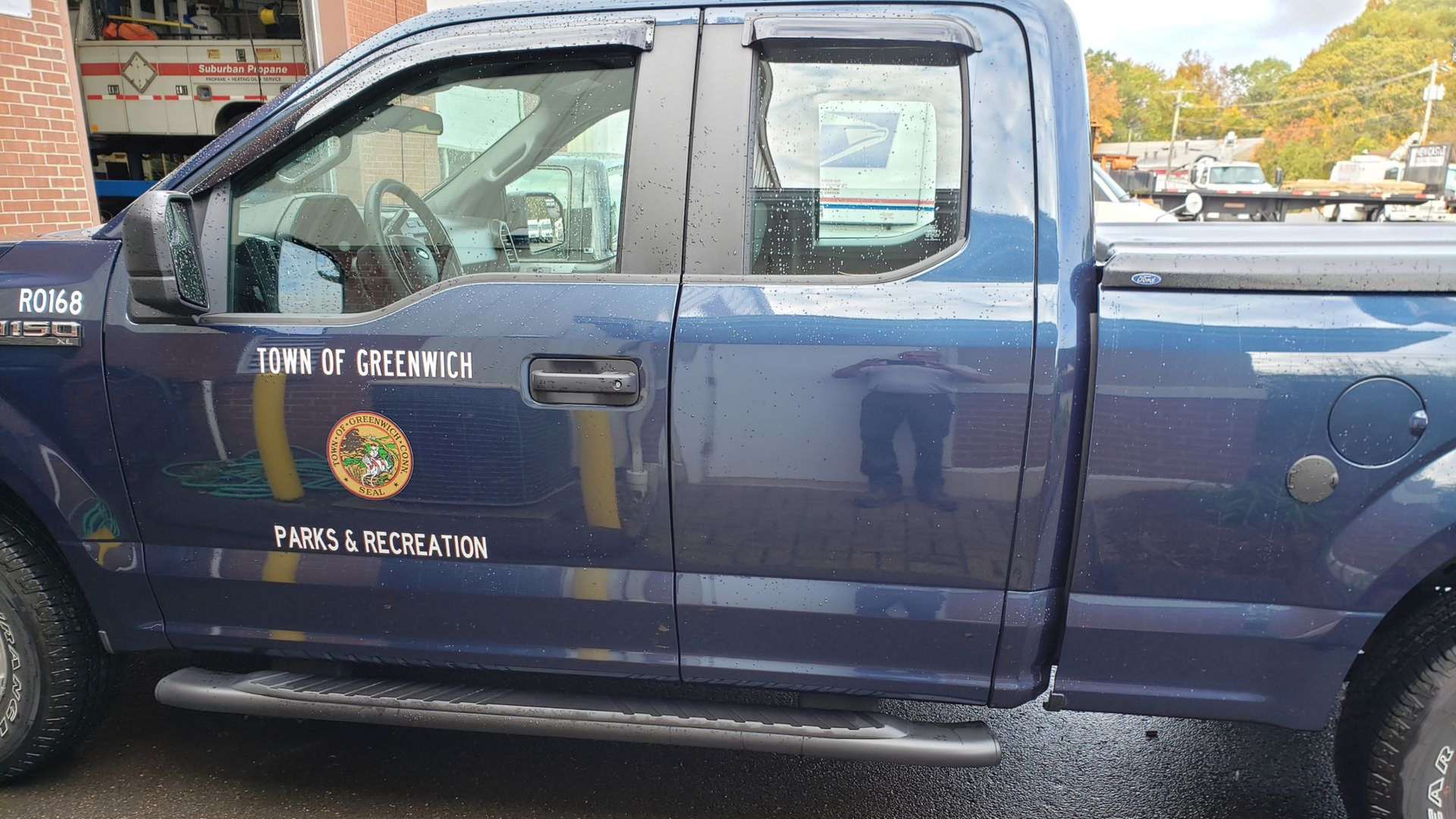 Blue pickup truck with Trinidad and Tobago Police Force markings parked on a street