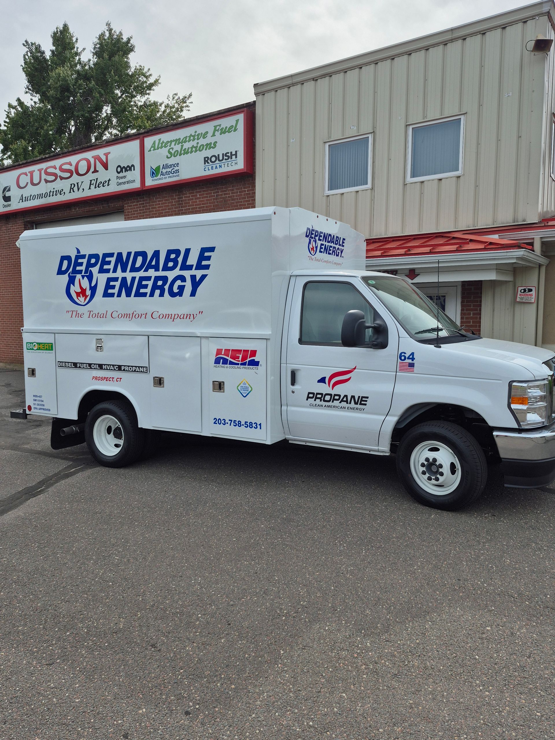 White Dependable Energy utility truck parked outside a building with red trim.