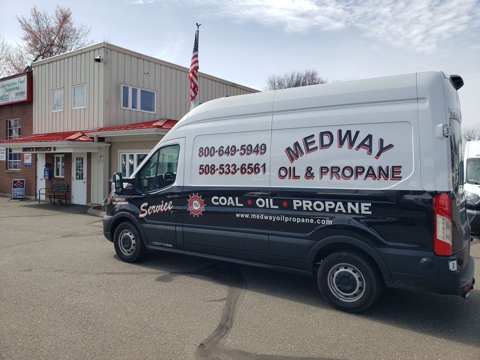 Meow oil and propane service van parked outside a small office building