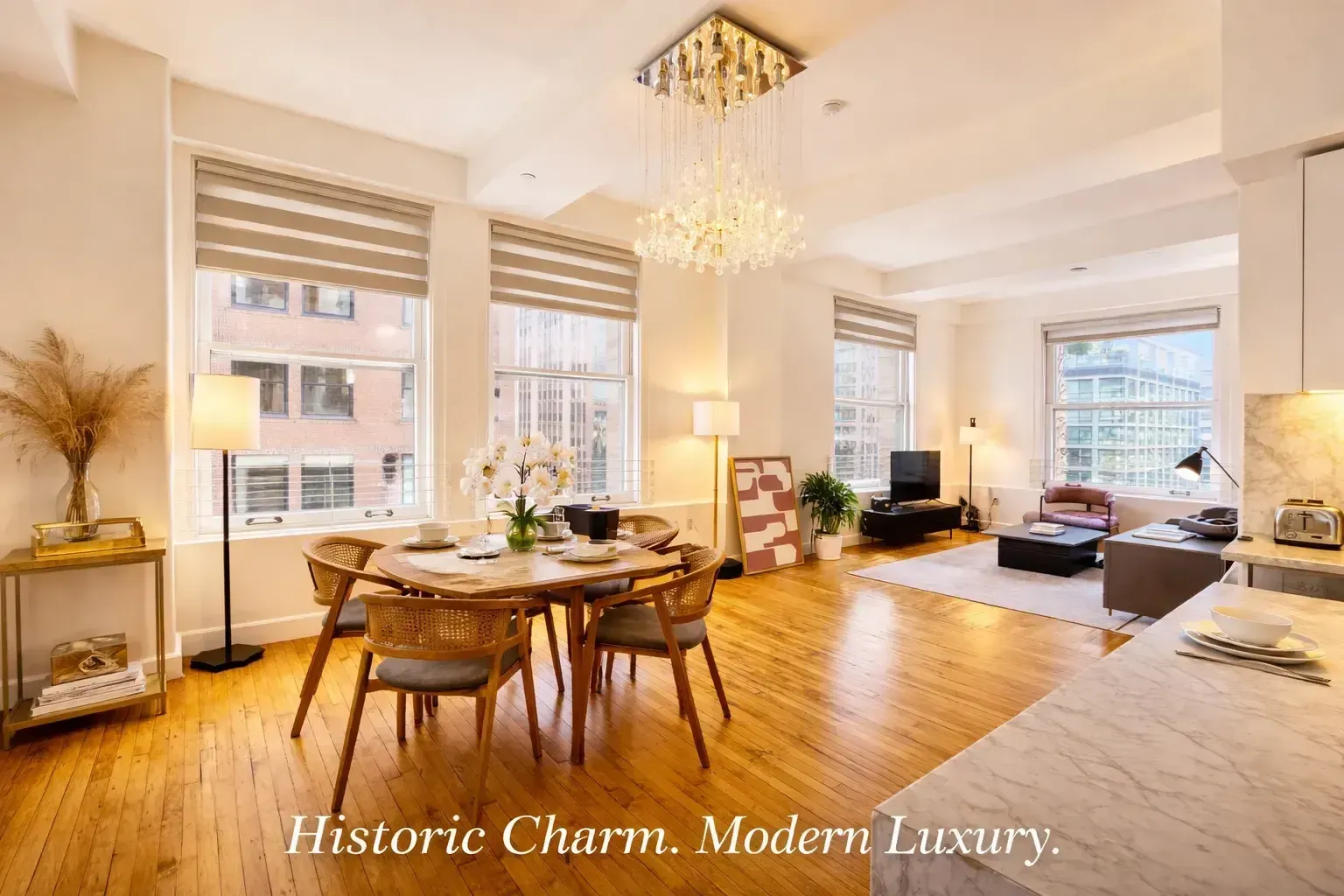 Bright, open-concept luxury two-bedroom apartment interior at HWH Luxury Living in Downtown LA, featuring hardwood floors, high ceilings, a modern dining area, and a spacious living room illuminated by large windows and a crystal chandelier. Overlaid with text that reads 