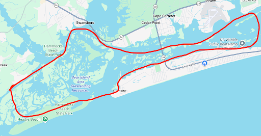 Red-outlined route loop on a map of a coastal city and surrounding water.