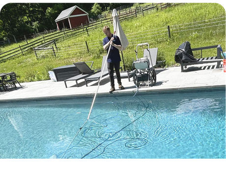 a man is cleaning a swimming pool with a broom .