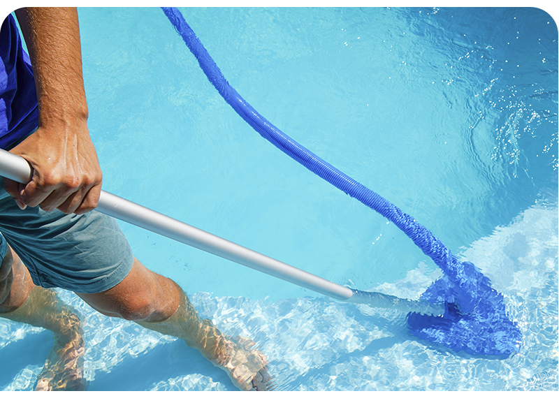 a man is cleaning a swimming pool with a broom .