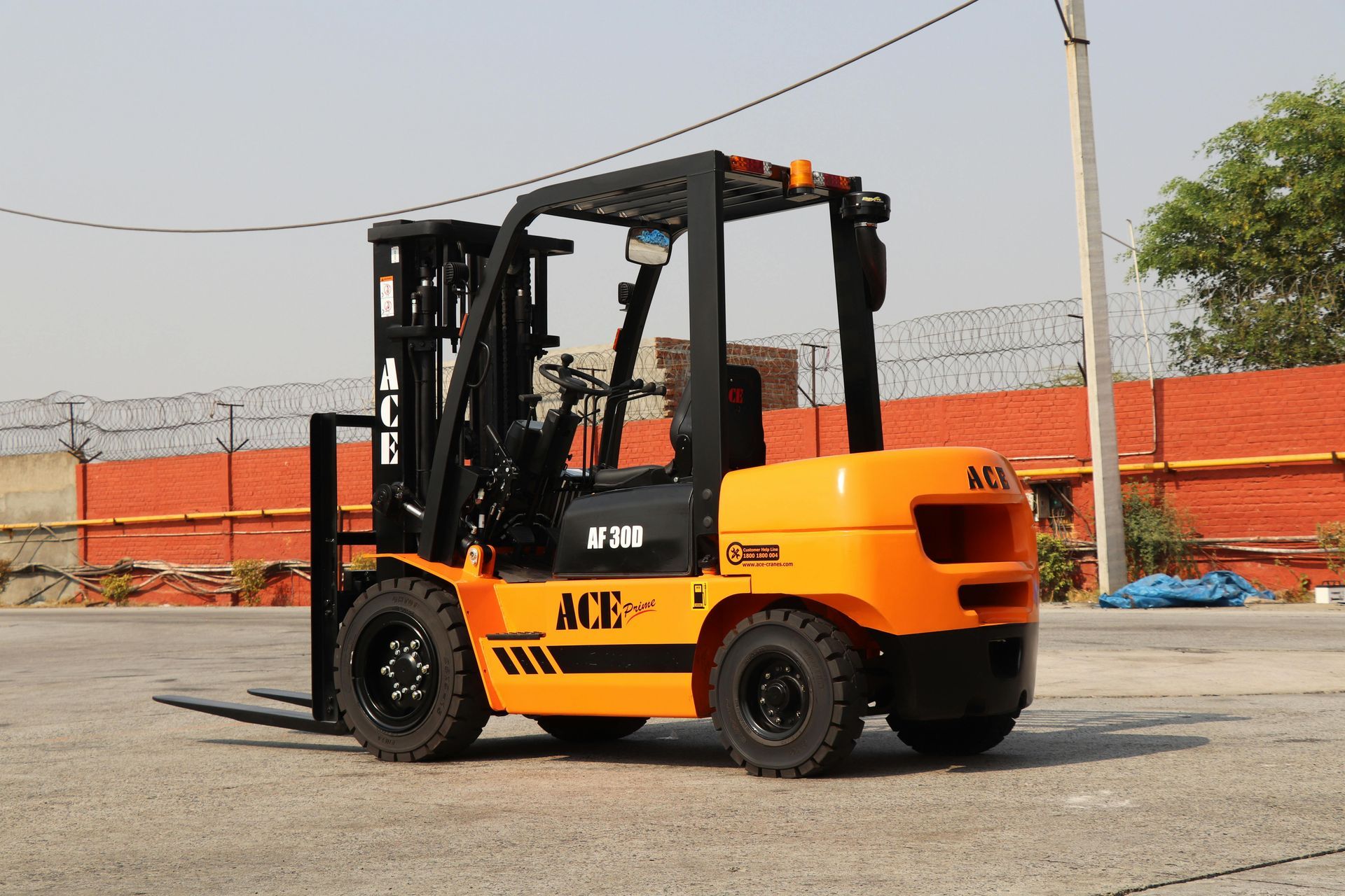 Orange ACE forklift outdoors on pavement.