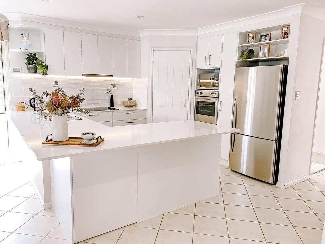 A Kitchen with White Cabinets and A Stainless Steel Refrigerator — Caldera Kitchens and Bathrooms in Lismore, NSW