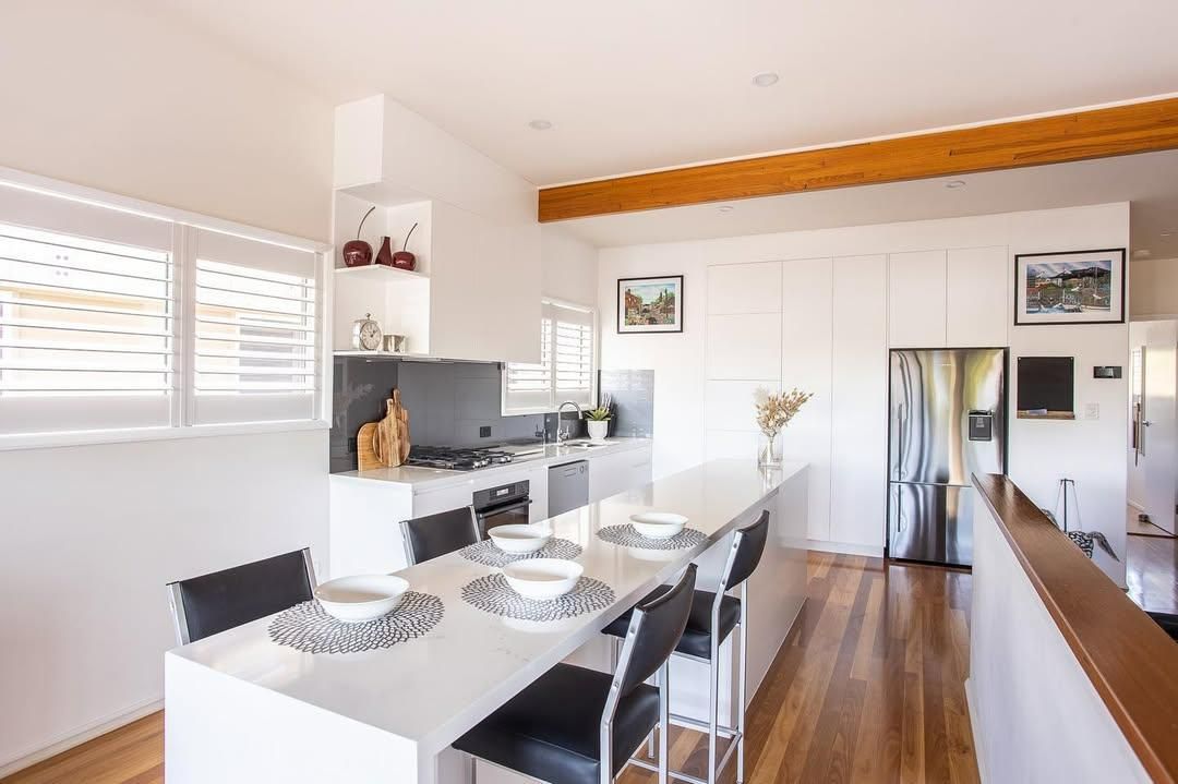 A Kitchen with A Table and Chairs and A Refrigerator — Caldera Kitchens and Bathrooms in Casino, NSW