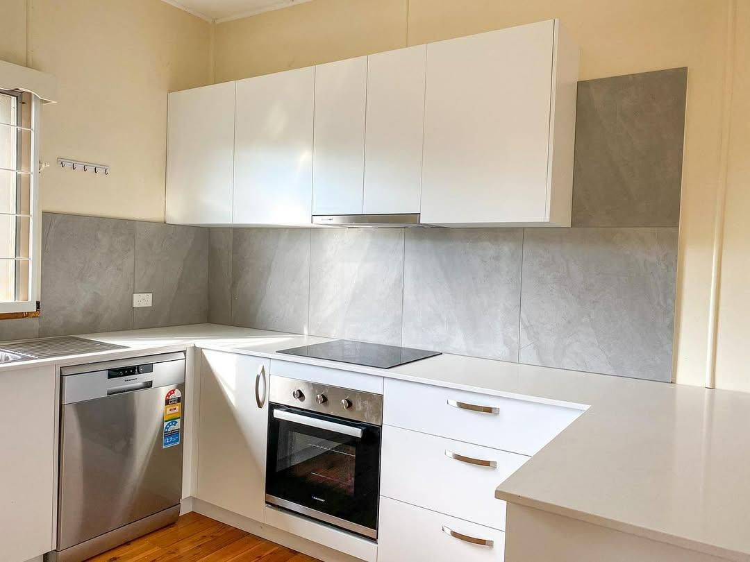 A Kitchen with White Cabinets and A Window — Caldera Kitchens and Bathrooms in Casino, NSW