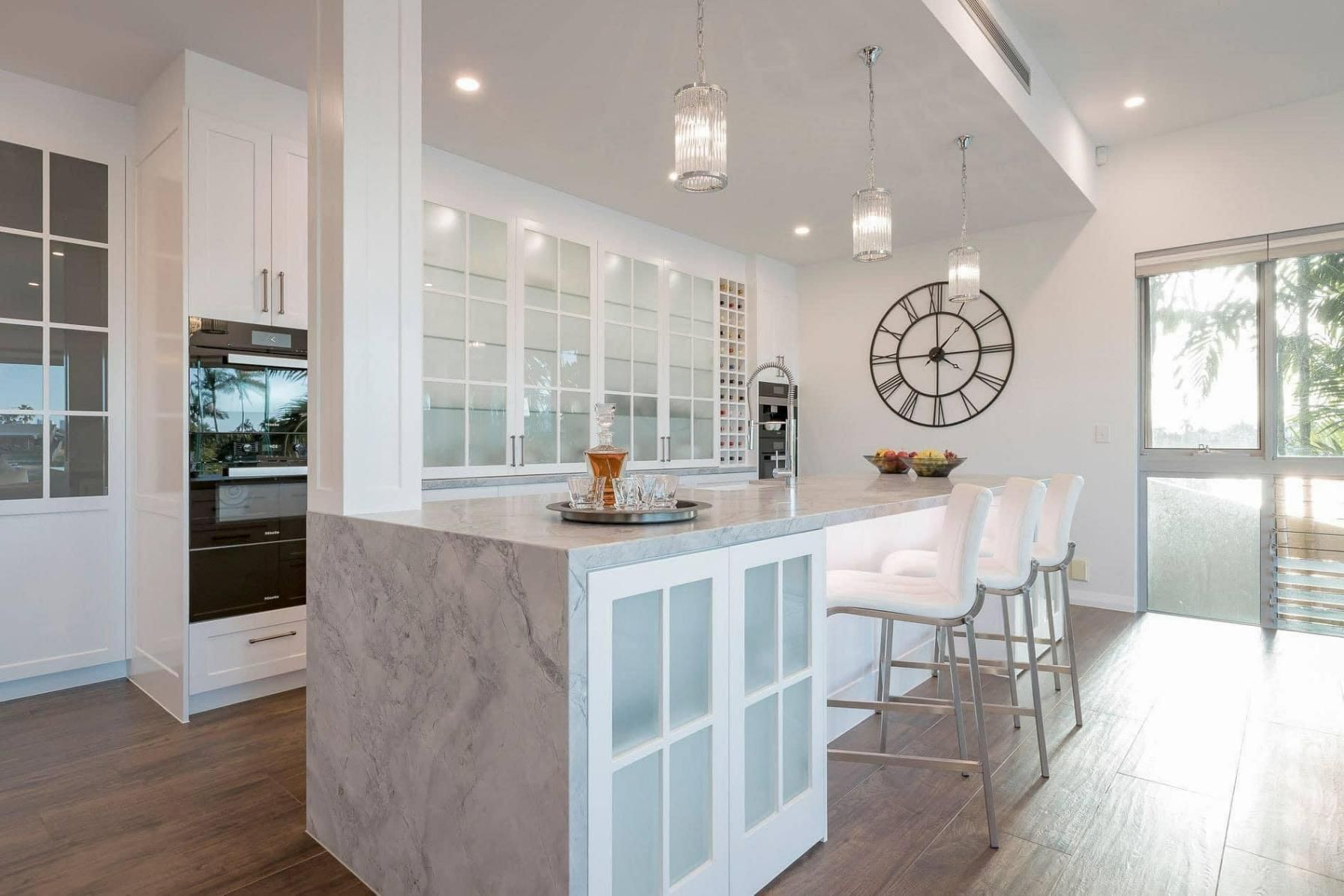 A Kitchen with A Large Island and A Clock on The Wall — Caldera Kitchens and Bathrooms in Lynchs Creek, NSW