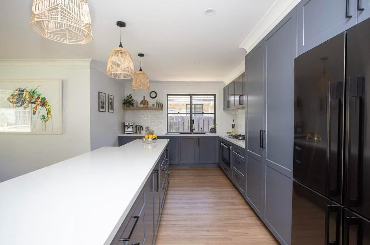 A Kitchen with Gray Cabinets and Black Appliances — Caldera Kitchens and Bathrooms in Lynchs Creek, NSW