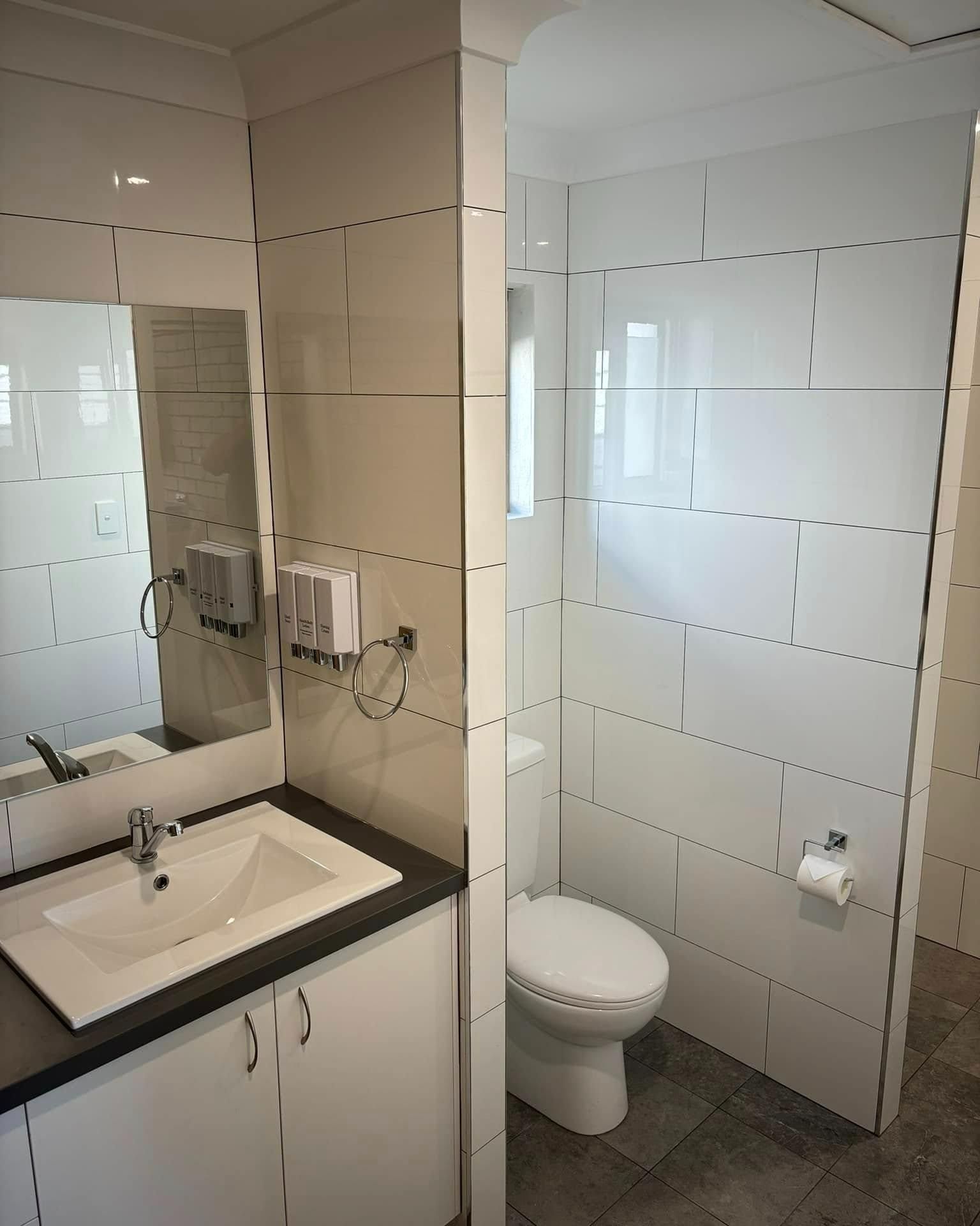 A Bathroom with A Sink , Toilet and Mirror — Caldera Kitchens and Bathrooms in Lynchs Creek, NSW