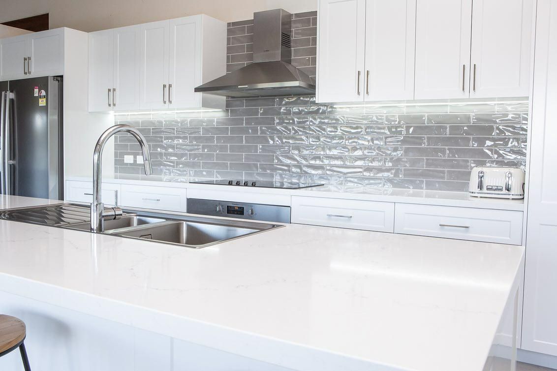 A Kitchen with White Cabinets, Stainless Steel Appliances — Caldera Kitchens and Bathrooms in Lynchs Creek, NSW