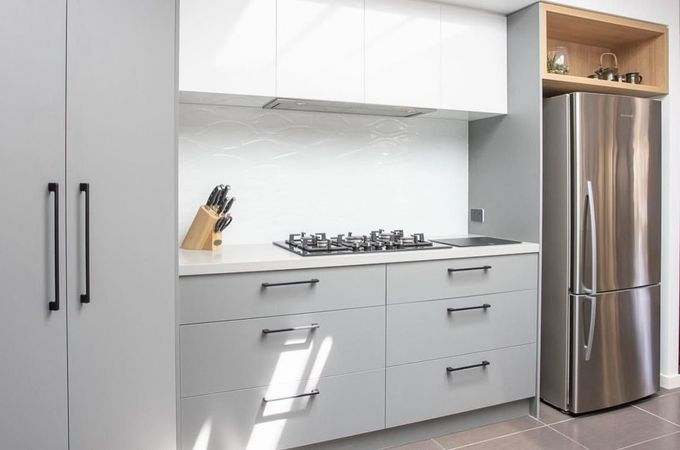 A Kitchen with White Cabinets and A Stainless Steel Refrigerator — Caldera Kitchens and Bathrooms in Lynchs Creek, NSW