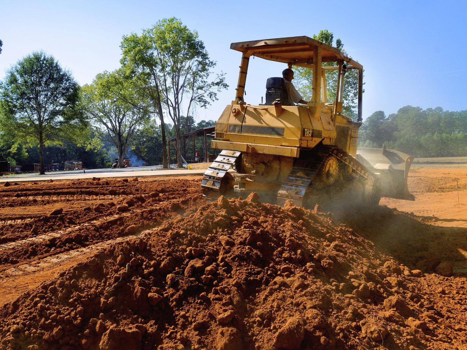 A bulldozer in action at a land clearing site.