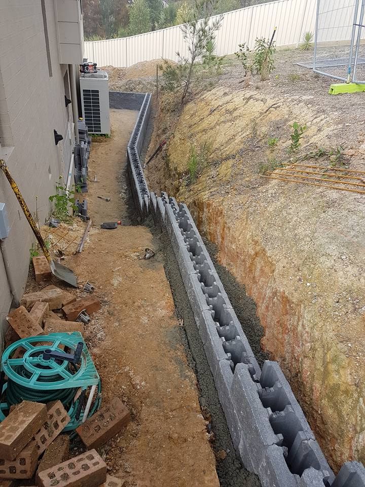 A brick wall is being built on the side of a house.