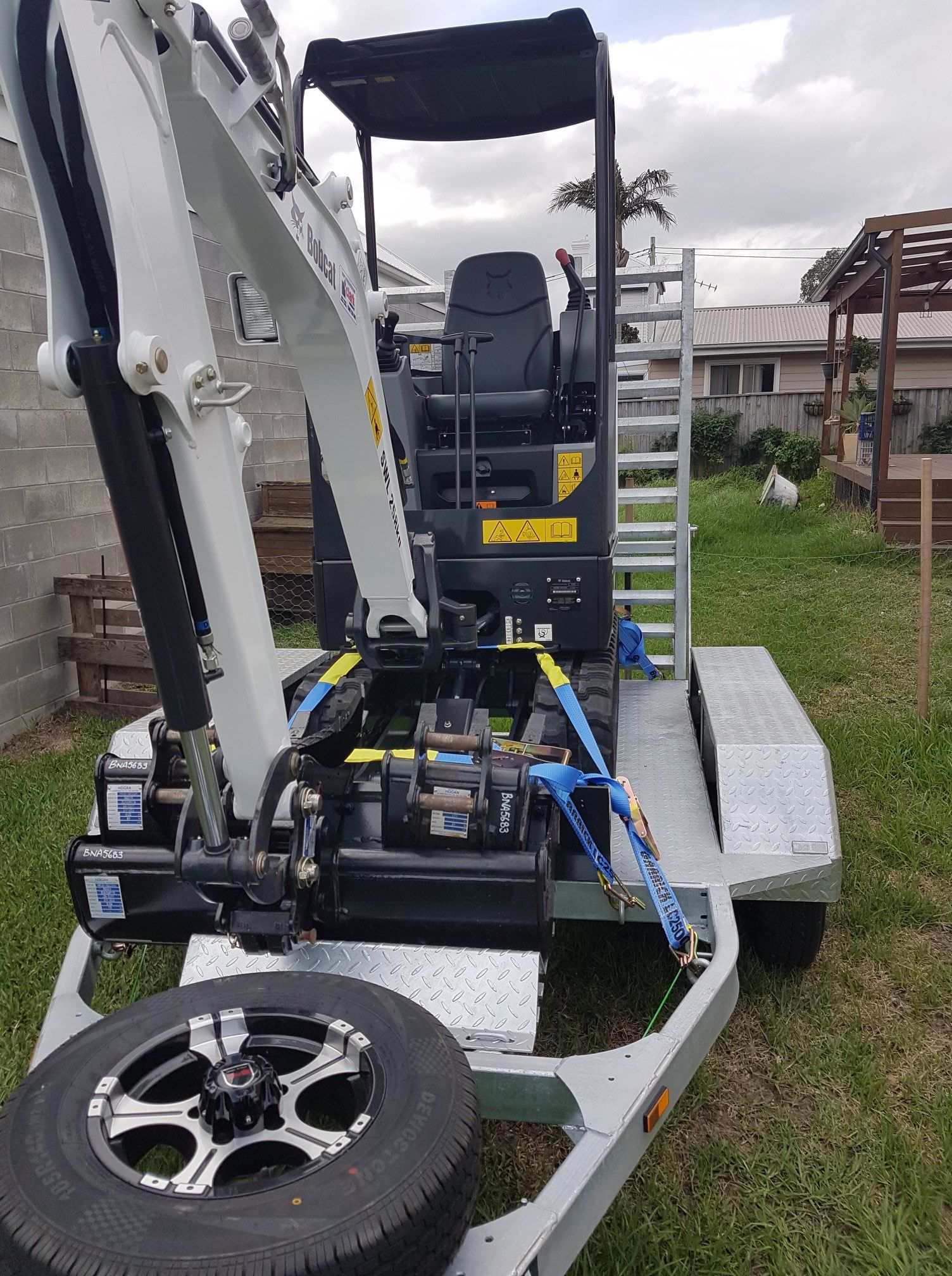 A small excavator is sitting on top of a trailer.
