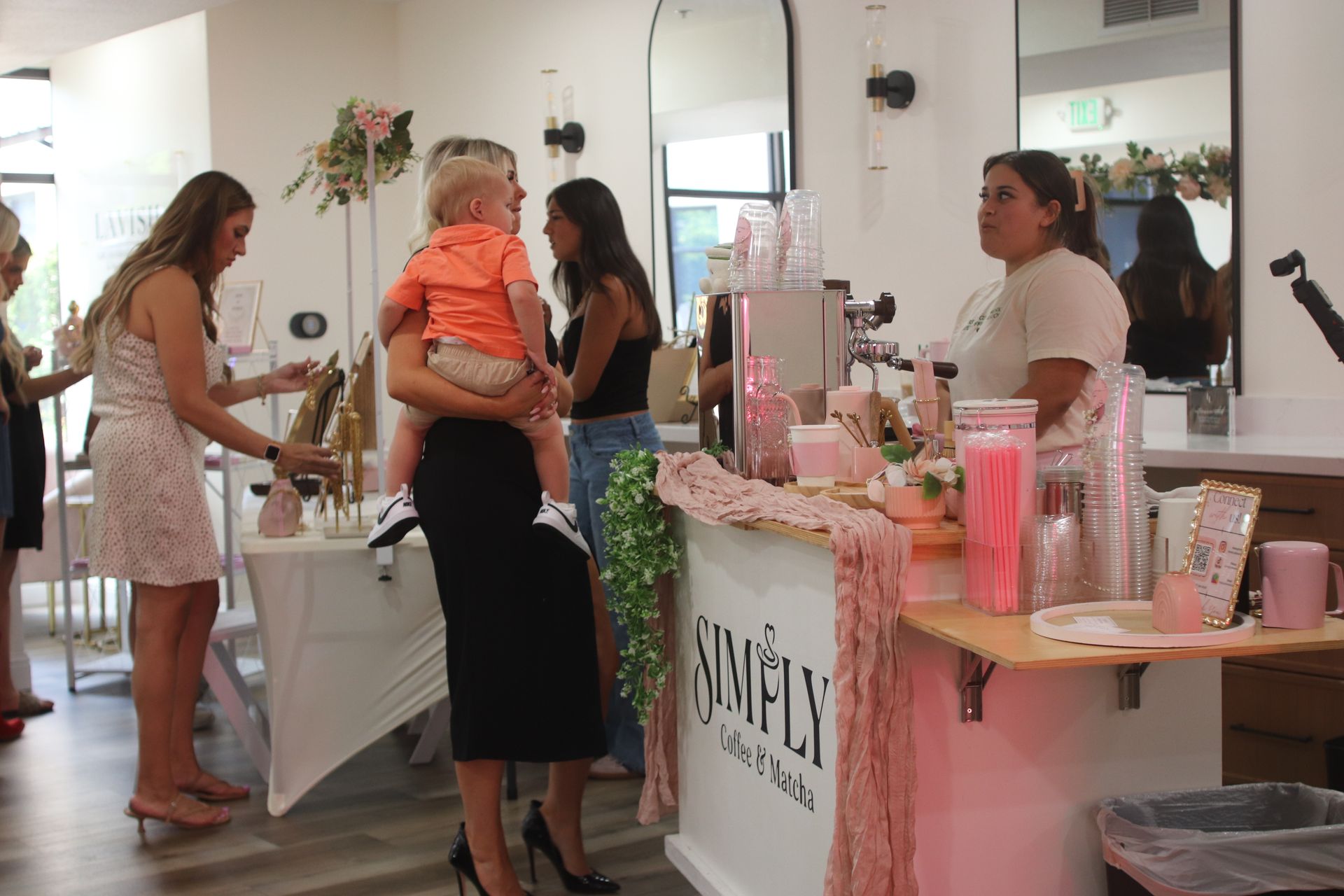 People browsing a pink-themed beauty boutique with product displays and mirrors