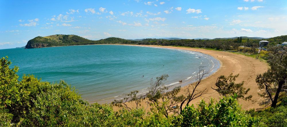 A Large Body Of Water With A Sandy Beach And Trees In The Foreground — Aquatic Pool & Spa Services In Capricorn Coast, QLD