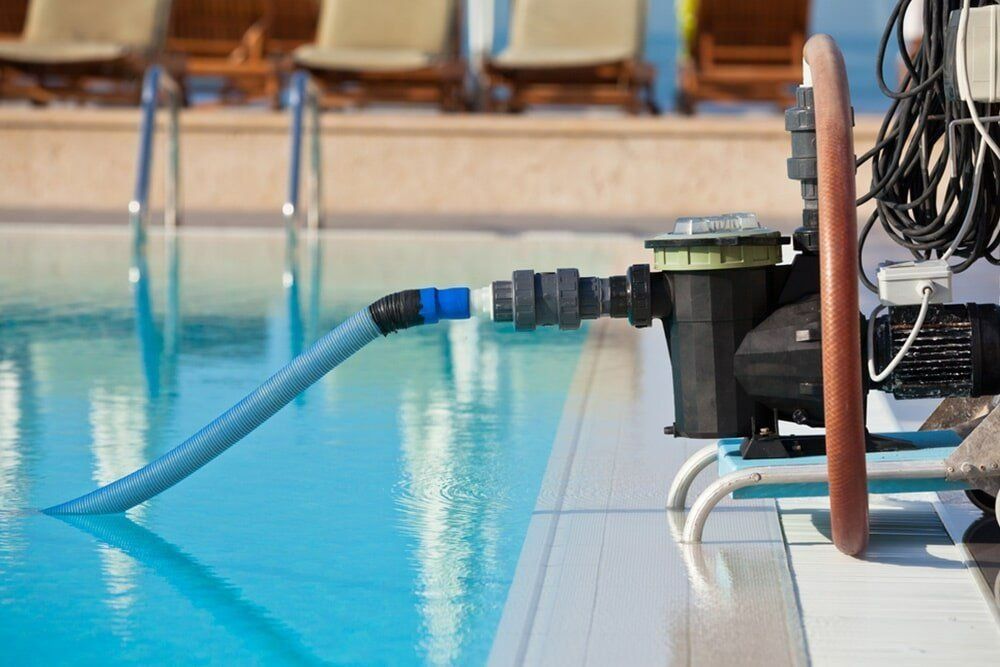 A Hose Is Attached To A Pump In A Swimming Pool — Aquatic Pool & Spa Services In Yeppoon, QLD