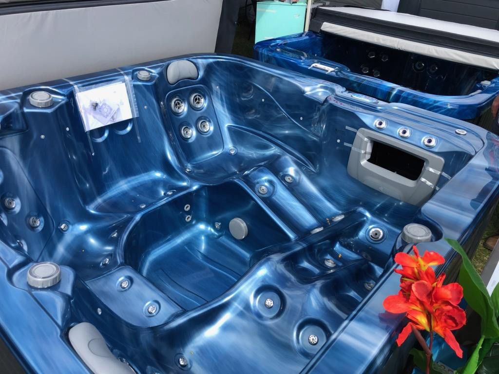 A Blue Hot Tub Is Sitting Next To A Flower — Aquatic Pool & Spa Services In Yeppoon, QLD
