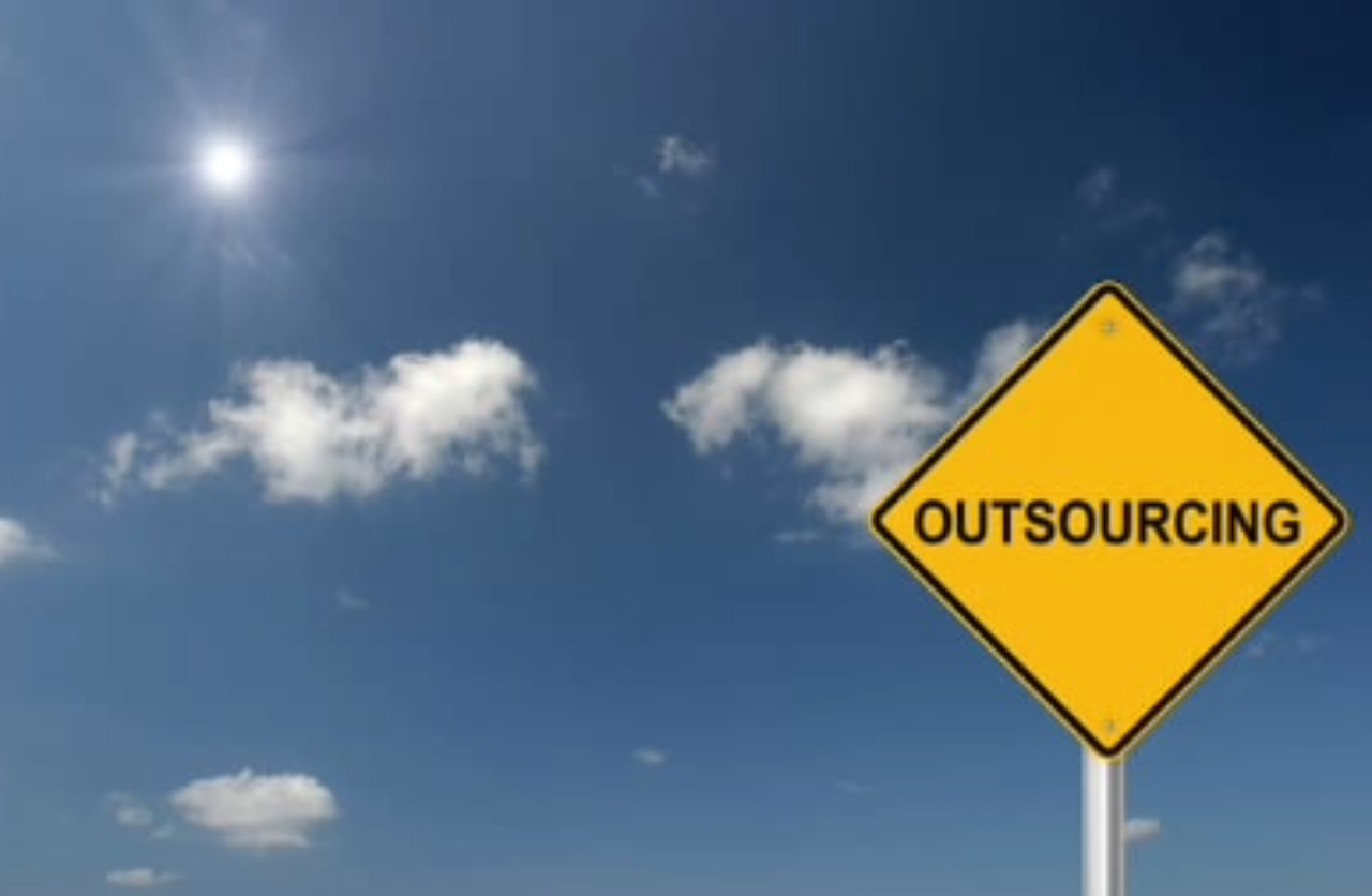A yellow sign with the word outsourcing on it.