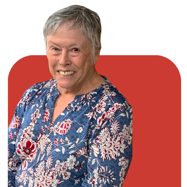 Smiling woman in a blue floral blouse standing before a red rounded background