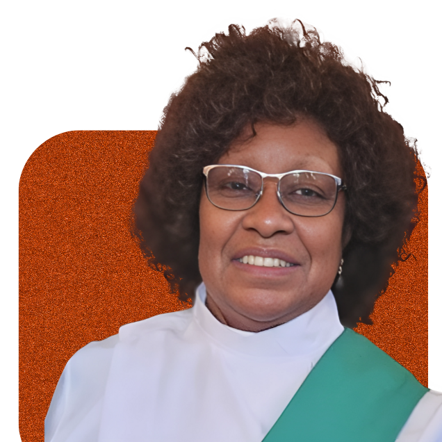 Smiling person with curly hair and glasses, wearing a white top and green sash on an orange background