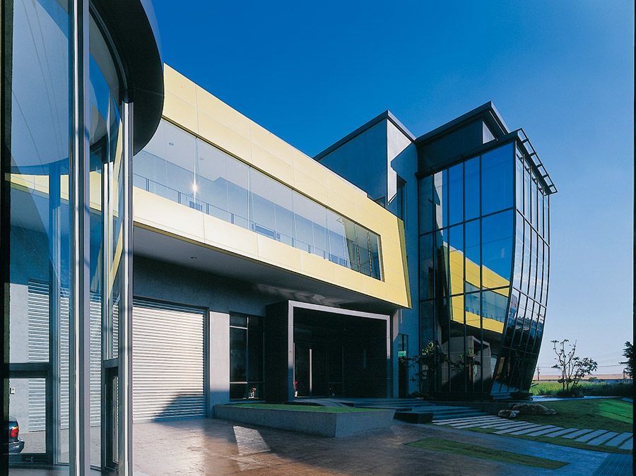 A large building with a lot of windows and a blue sky in the background