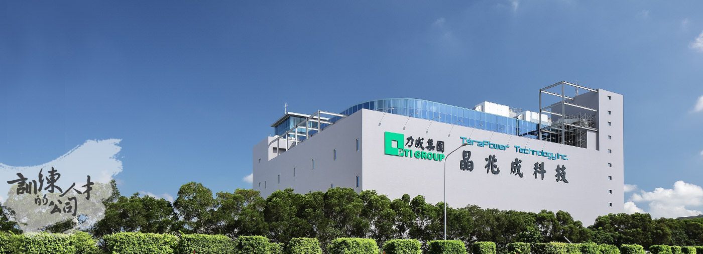 A large white building with chinese writing on it is surrounded by trees.