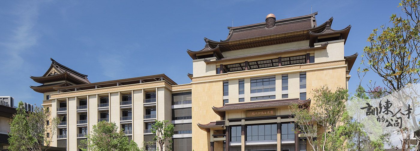 A large building with a chinese style roof is surrounded by trees.