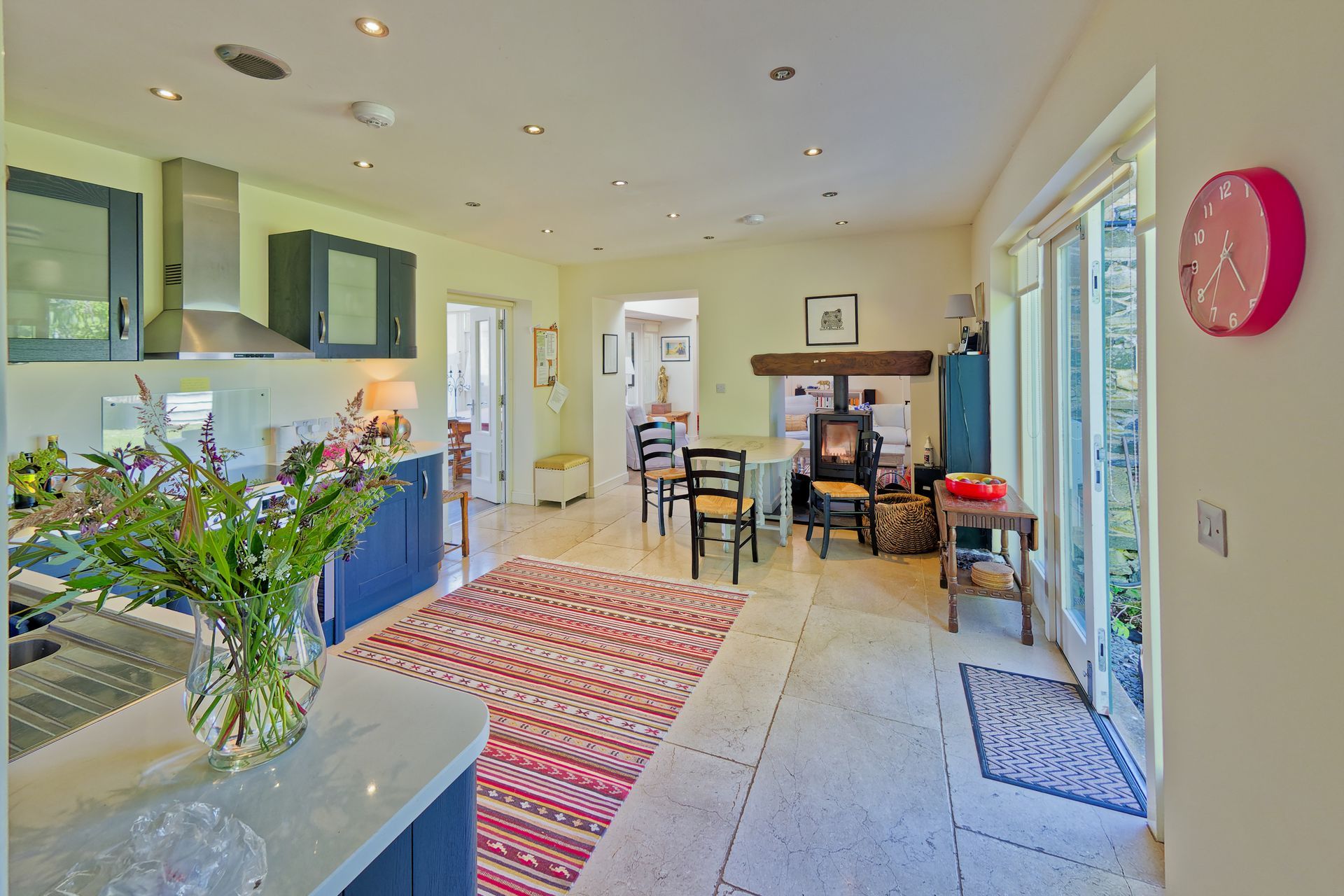 A kitchen with a table and chairs and a wood burner