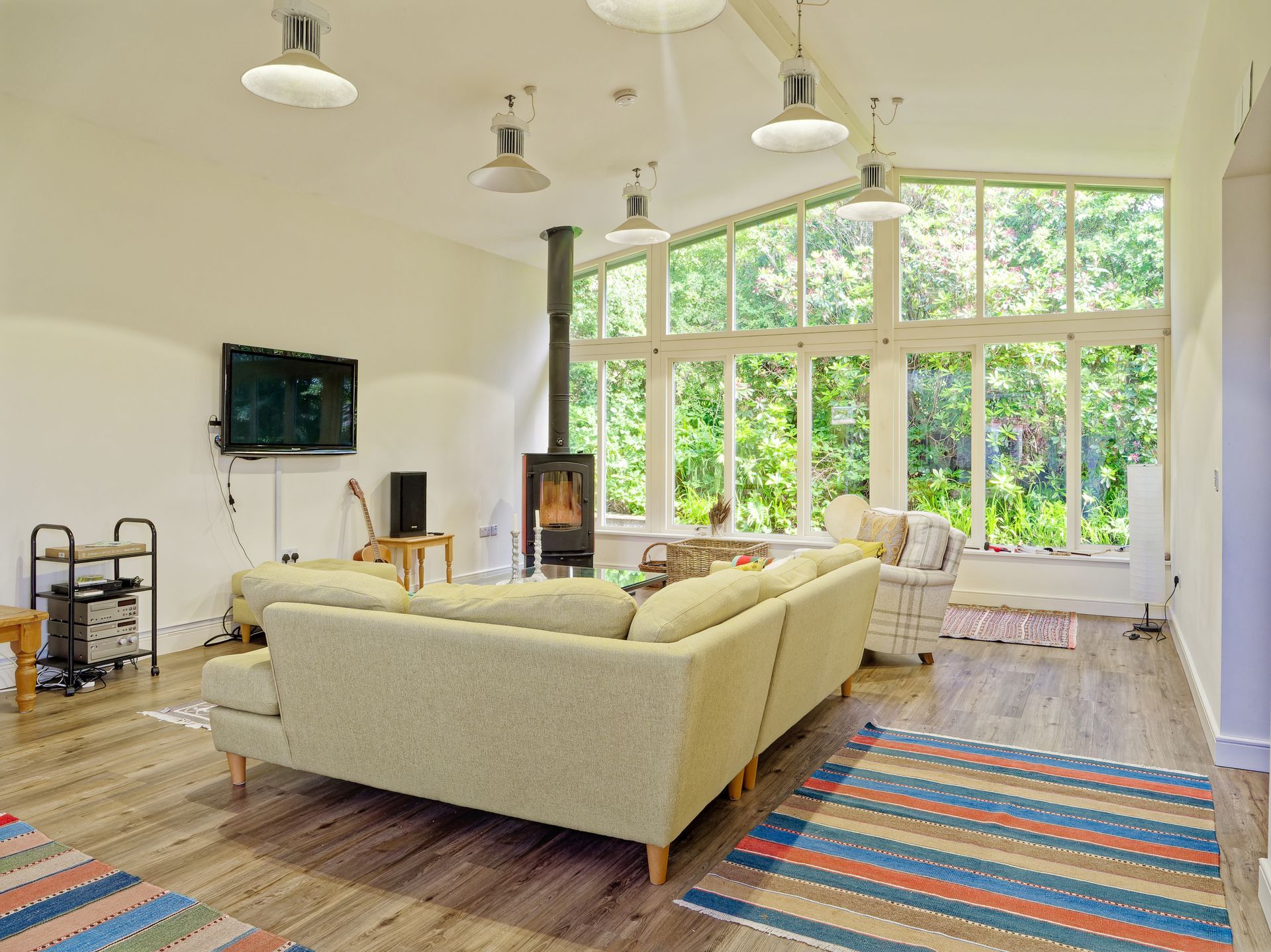 A living room with a large sectional couch and a flat screen tv.