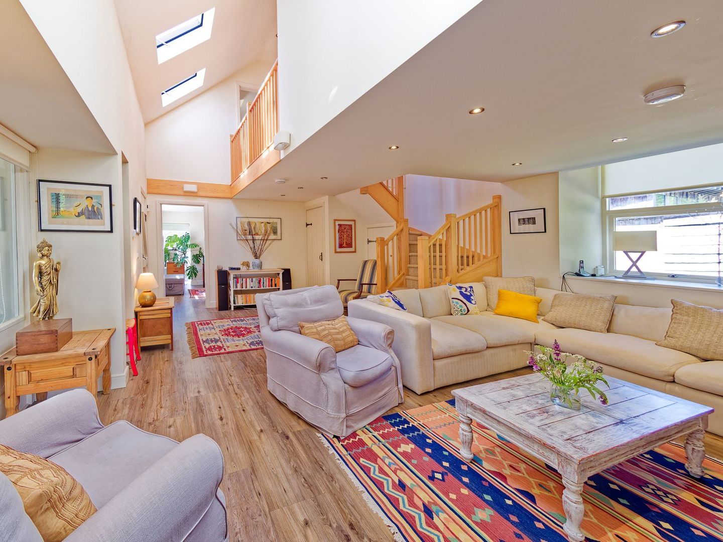 A living room with a couch , chair , coffee table and rug.
