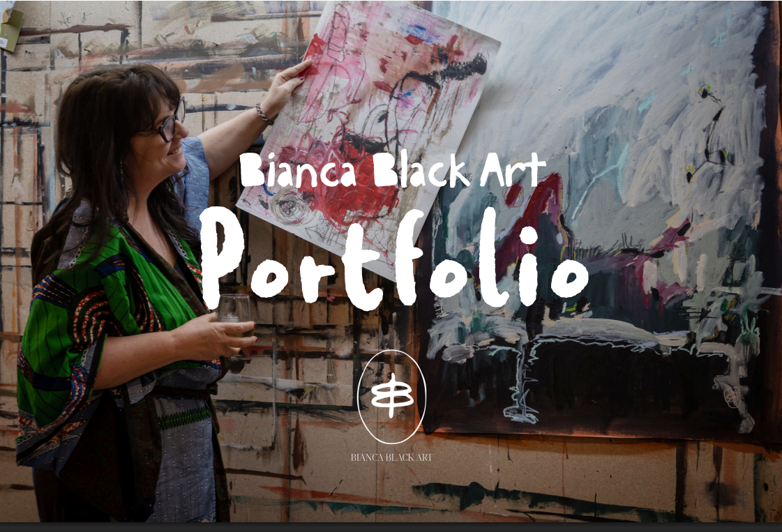 An artist holds up a painted canvas in a studio beside a large abstract painting, with 