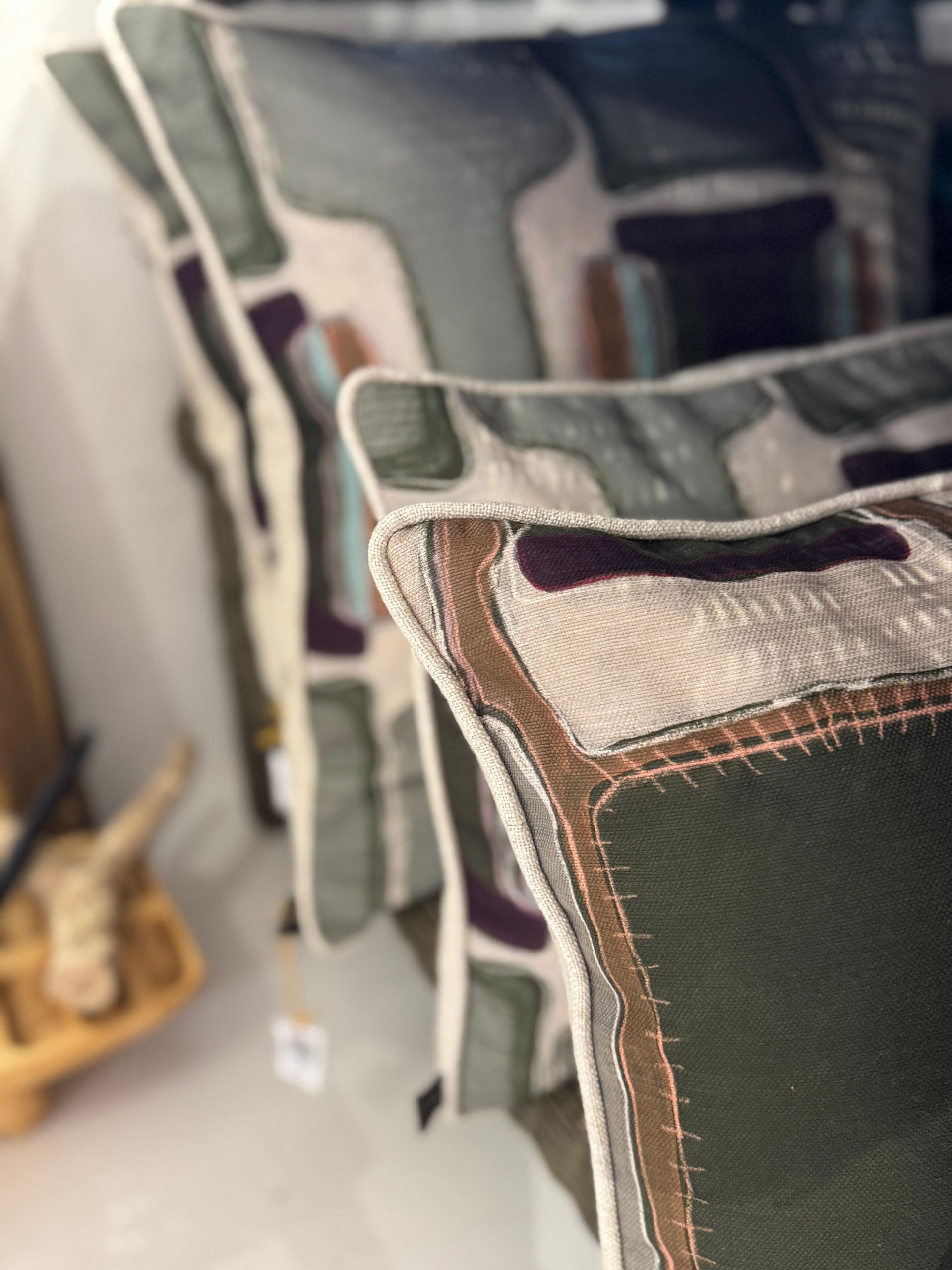 Stacked mesh chairs with patterned cushions in muted green and beige tones