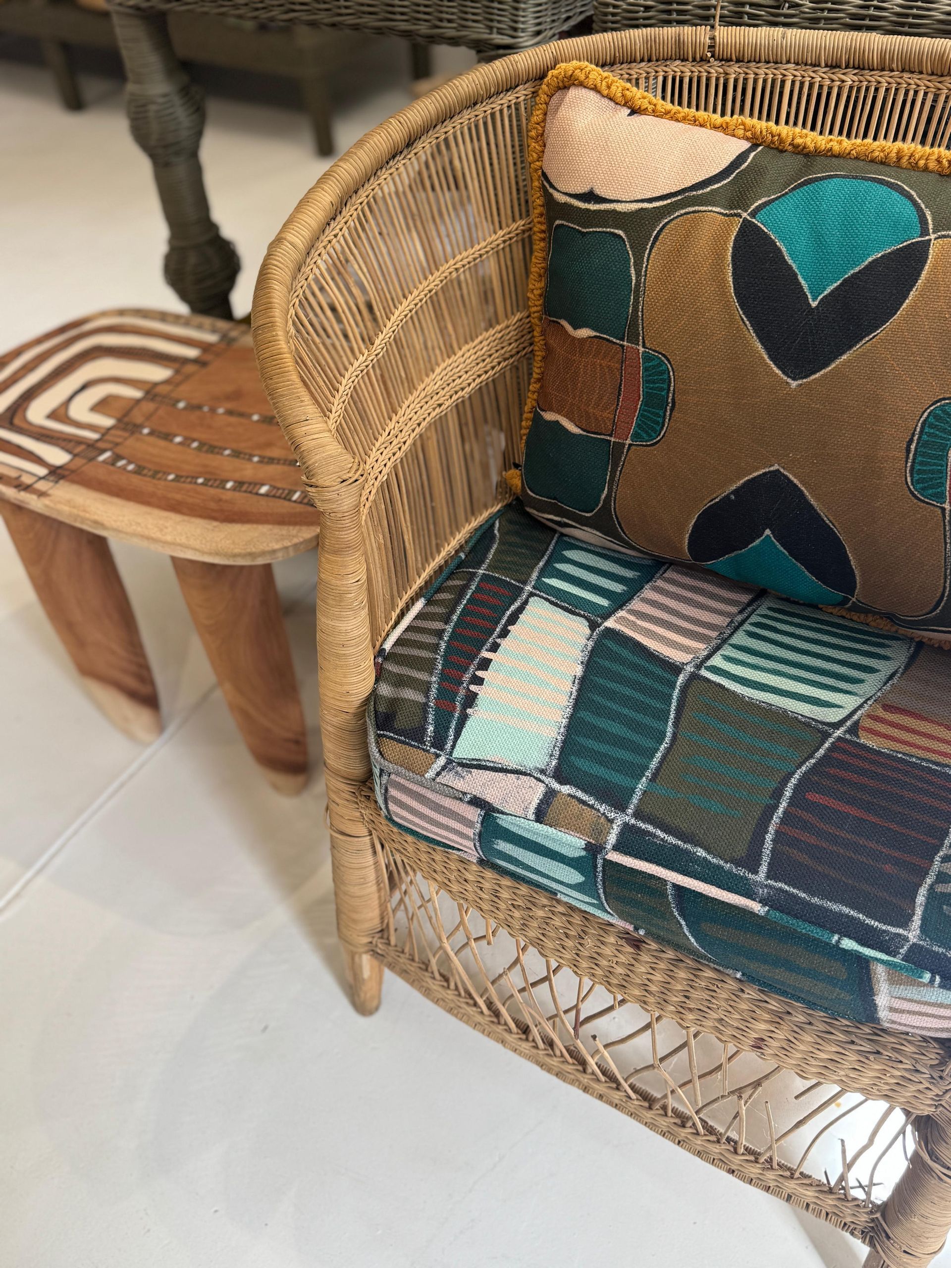 Stacked mesh chairs with patterned cushions in muted green and beige tones