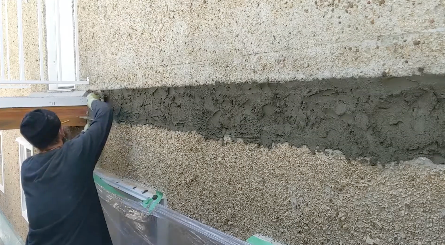 contractor applying stucco to wall.